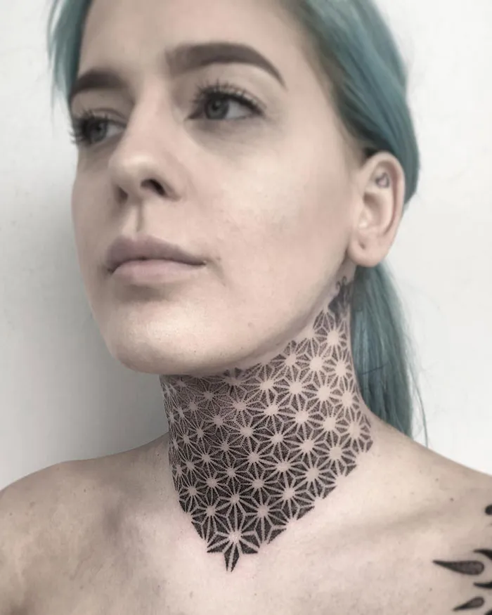 Person with a geometric tattoo design covering the neck.