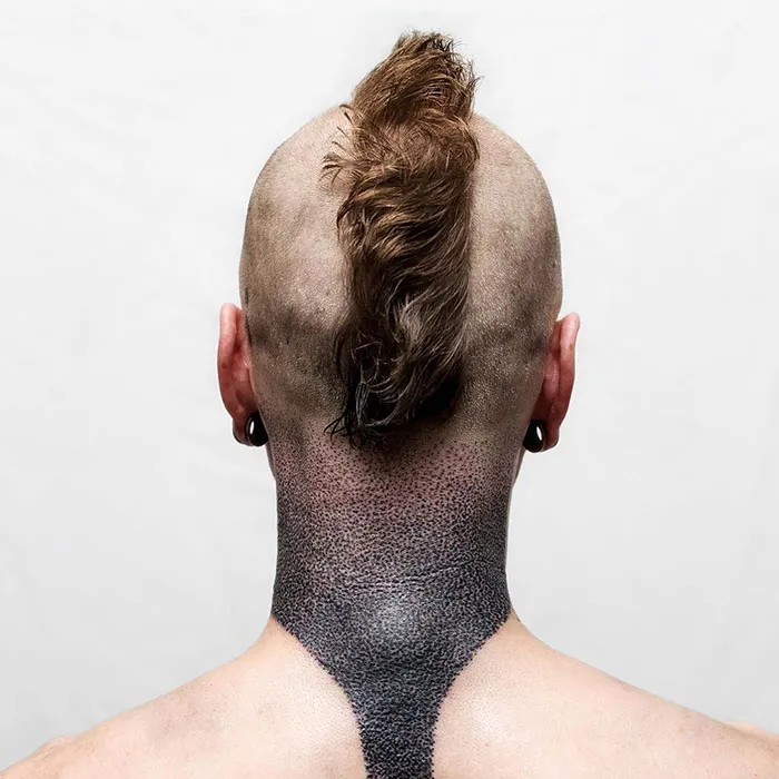 Unique neck tattoo design on a person with a mohawk hairstyle, showcasing creative inked art.