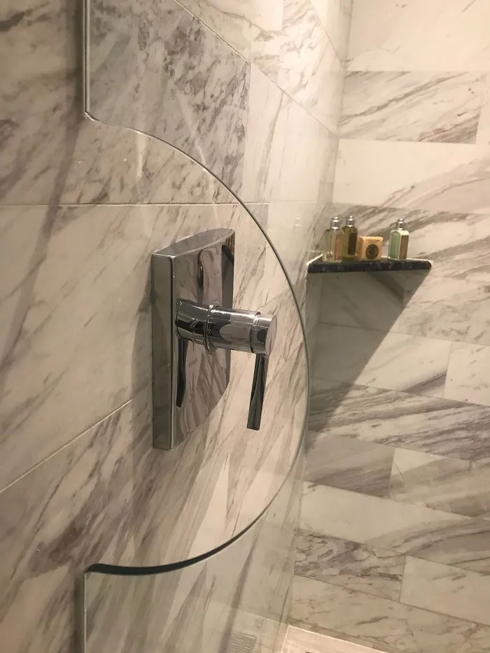 La ducha del hotel tiene este agujero en la mampara para poder encenderla antes de meterte