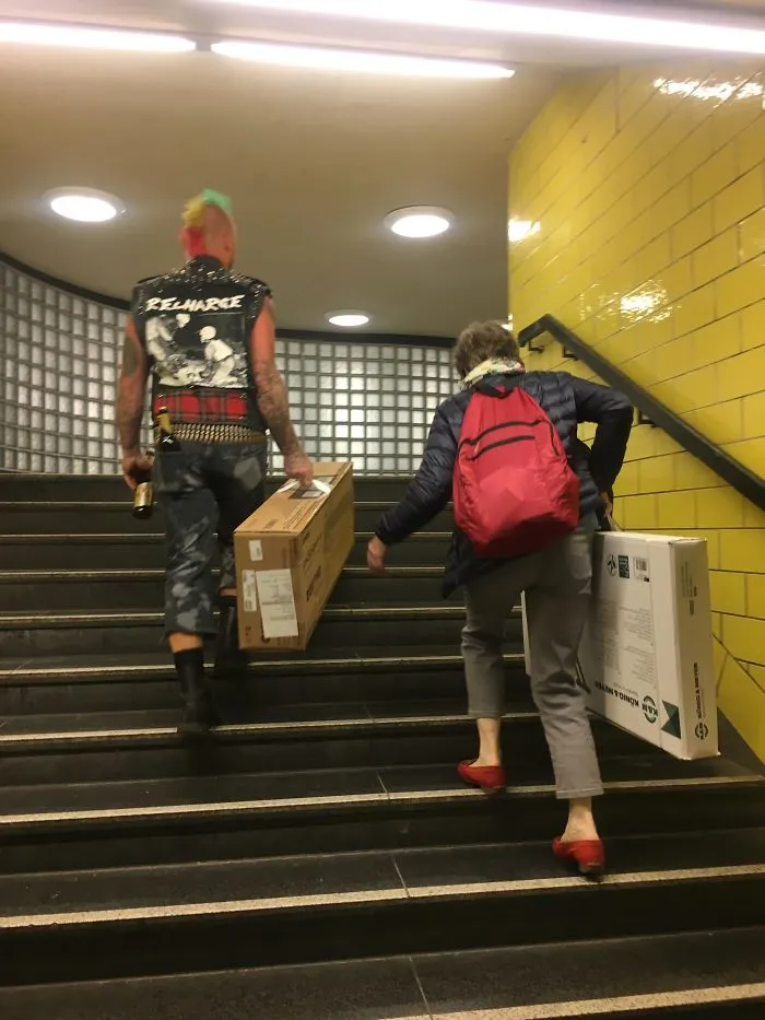 Un punki ayudando a una mujer con su pesada carga en el metro de Berlín