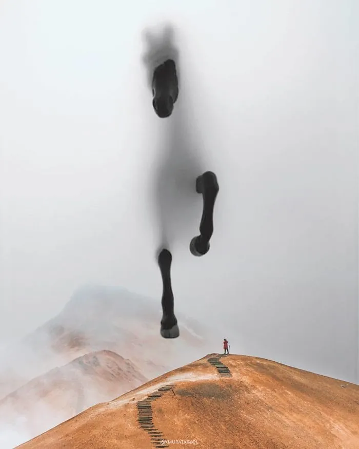 Surreal photo of a misty mountain landscape with a large, shadowy horse figure looming overhead.