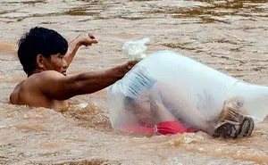 Schoolkids In Vietnam Village Ferried Across River In Plastic Bags To Get To School