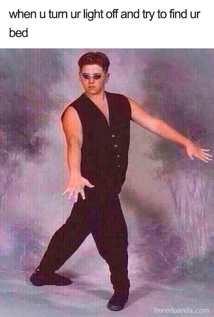 Man in sunglasses and black outfit cautiously reaching out in the dark, depicting a funny sleeping meme moment.