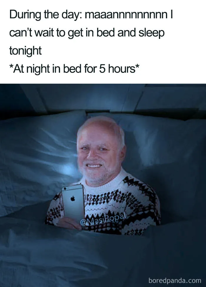 Man in bed using a smartphone at night with a reluctant smile, illustrating funny sleeping memes and bedtime struggles.