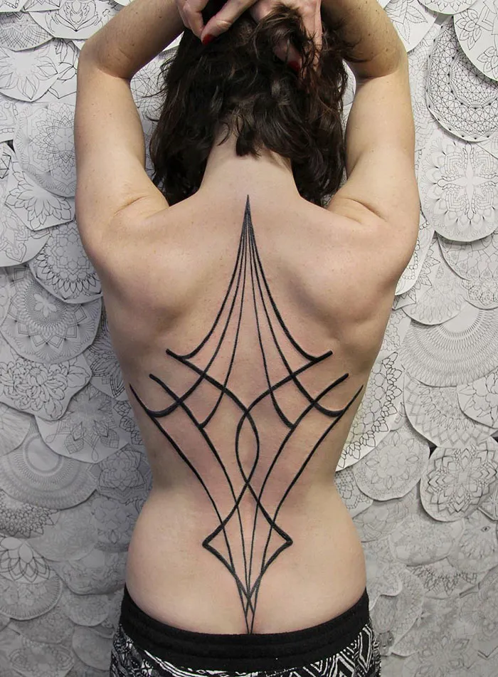 Intricate geometric back tattoo design on a person's skin, showcasing impressive tattoo artistry.