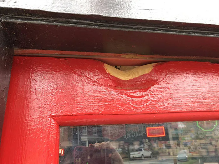 Puerta desgastada después de golpear la campanilla durante 50 años