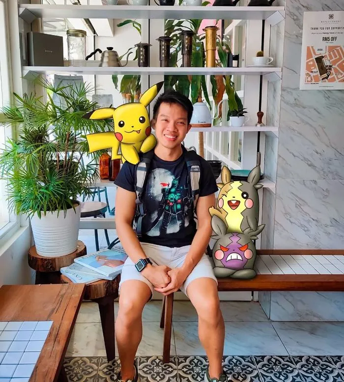 Person sitting with Pokémon illustrations in a cafe.