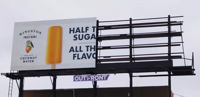 Esta campaña de una empresa utiliza solo la mitad de la valla publicitaria para indicar que tiene la mitad de azúcar