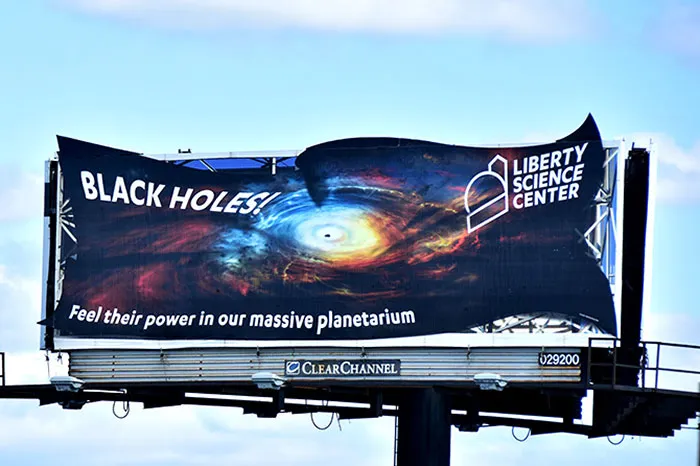 Vi este letrero que anuncia un planetario sobre un agujero negro en el Liberty Science Center. Definitivamente la mejor valla que he 