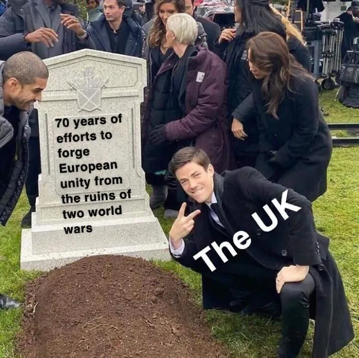 A man posing with 'The UK' text in front of a humorous Brexit-themed gravestone.
