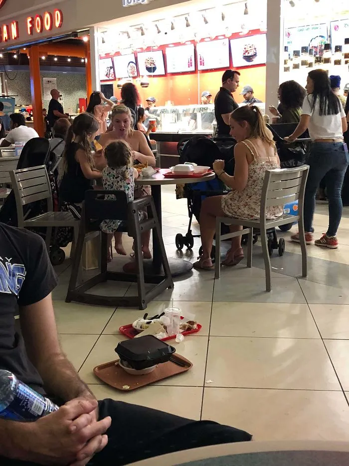 Vi cómo esta familia dejaba las bandejas llenas de comida en el piso en lugar de desecharlas. Las recogí solo después de ver cómo alguien se tropezaba con ellas