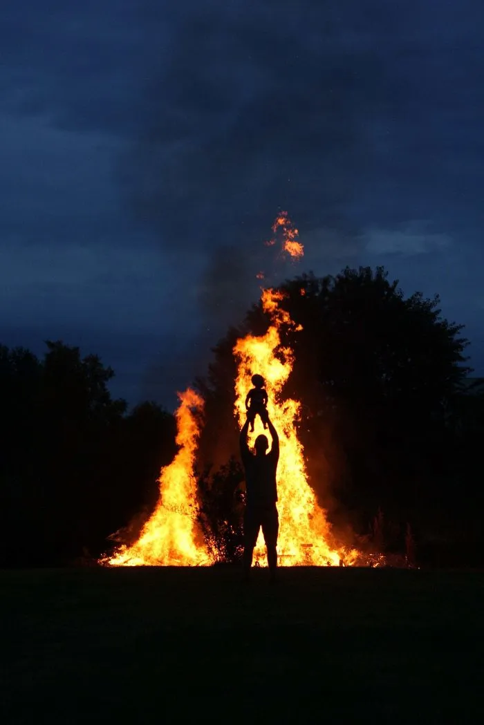 At A Bonfire. Wife Instructs Me To Hold My One Year Old Son High To Get A "Cool Shot". I Think It Looks Like I'm About To Sacrifice Him
