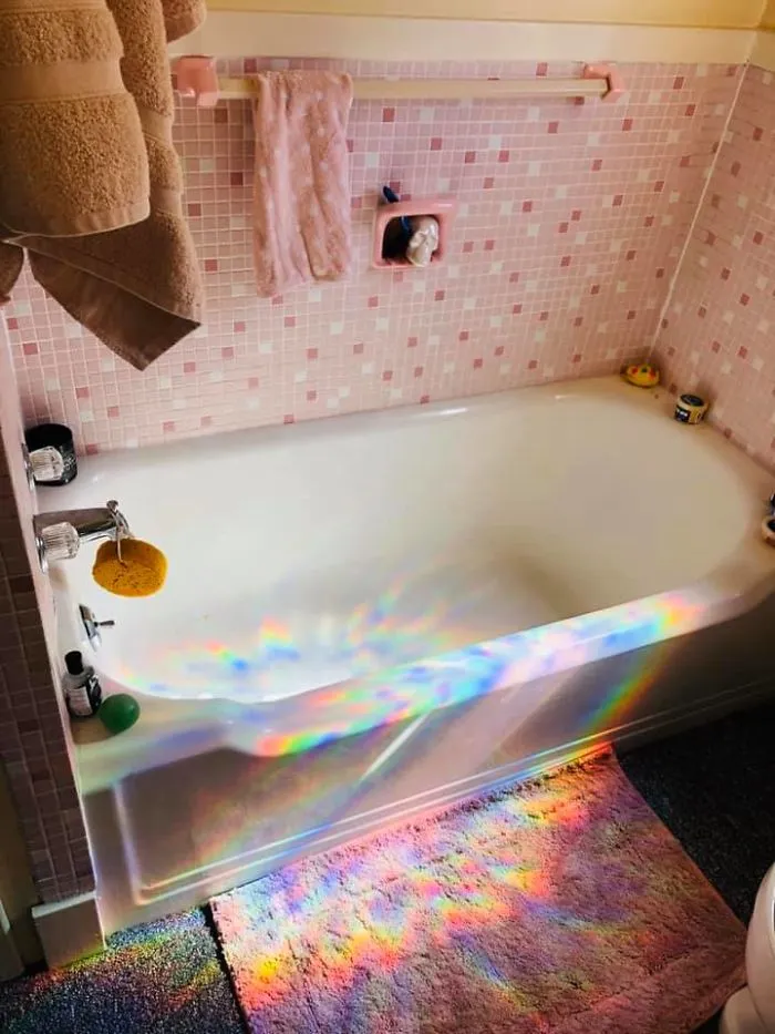 The Window Is Covered Over With A Rainbow Reflecting Window Cling