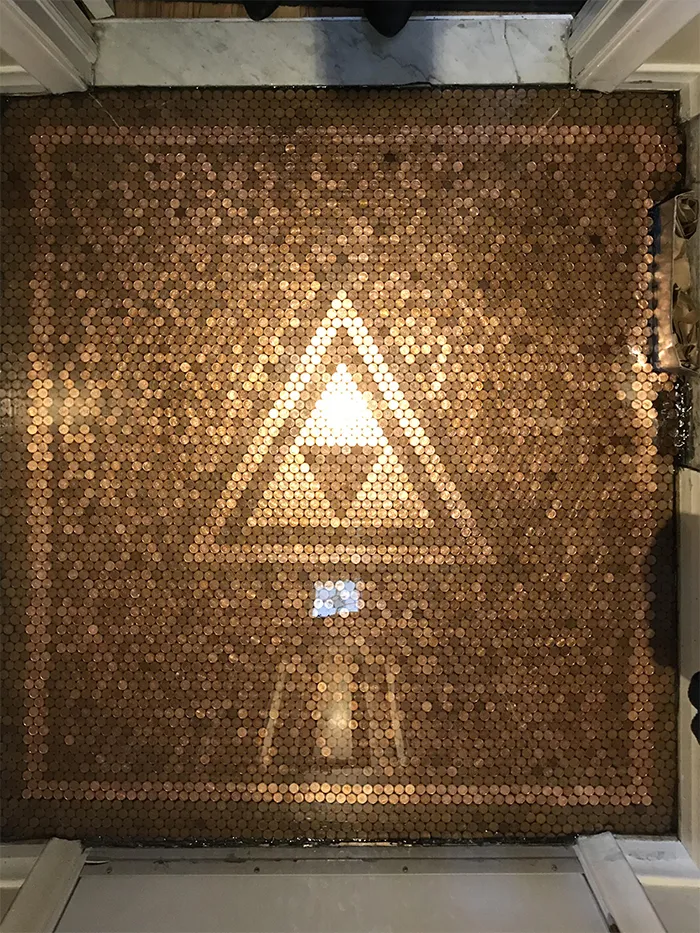 Suelo cubierto de peniques con el símbolo Triforce