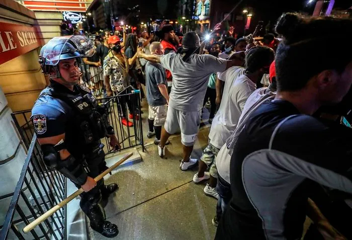 A Group Of Black People Protecting A Cop Who Got Separated From The Others