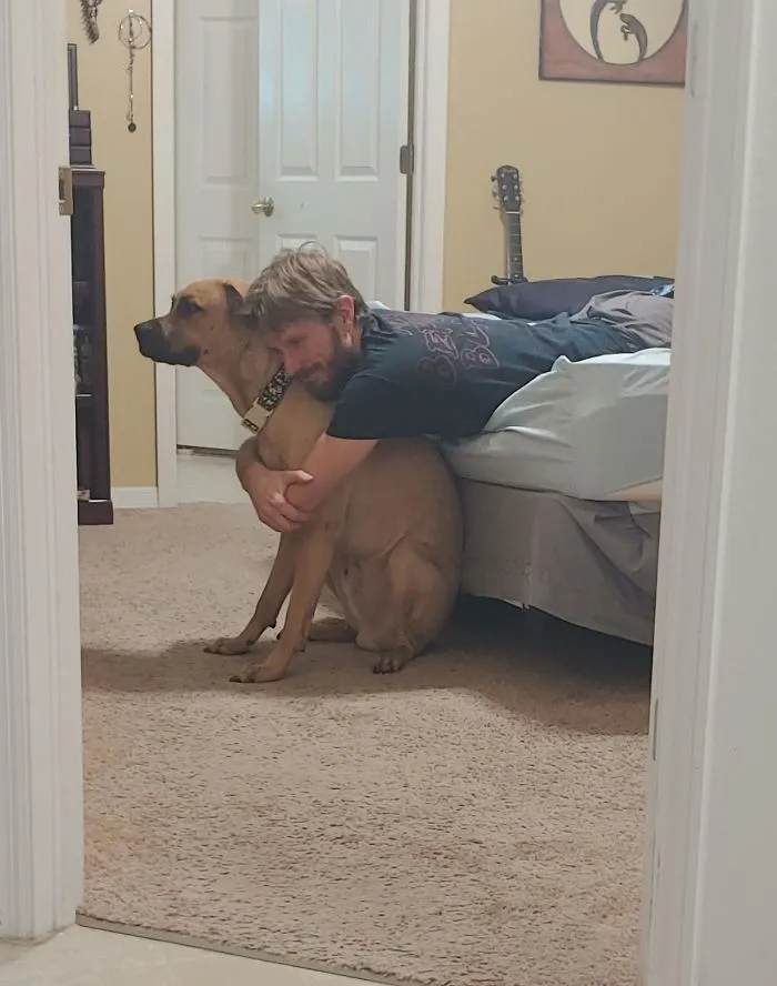 Le pillé abrazando al perro gigante que no quería y cantándole una canción