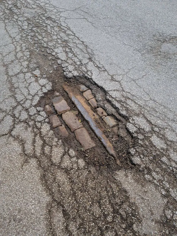 After A Hard Rain, A Pothole Opened Up In Front Of My House Revealing The Original Brick And A Train Track