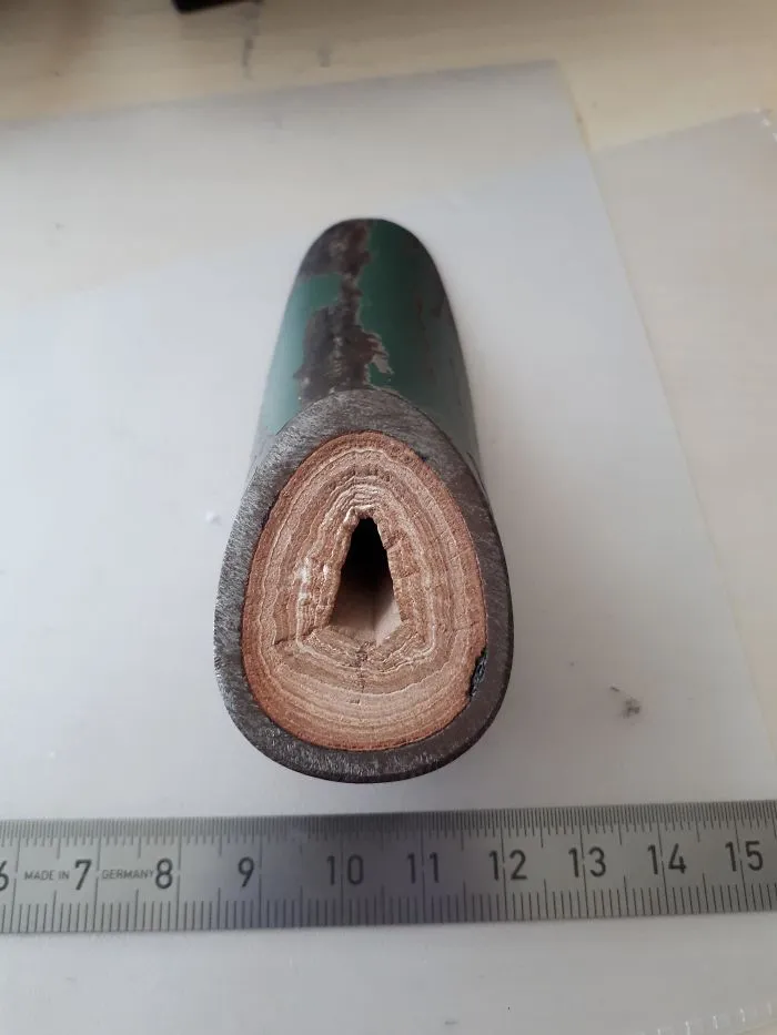 Antigua tubería cortada mostrando las capas de cal formadas