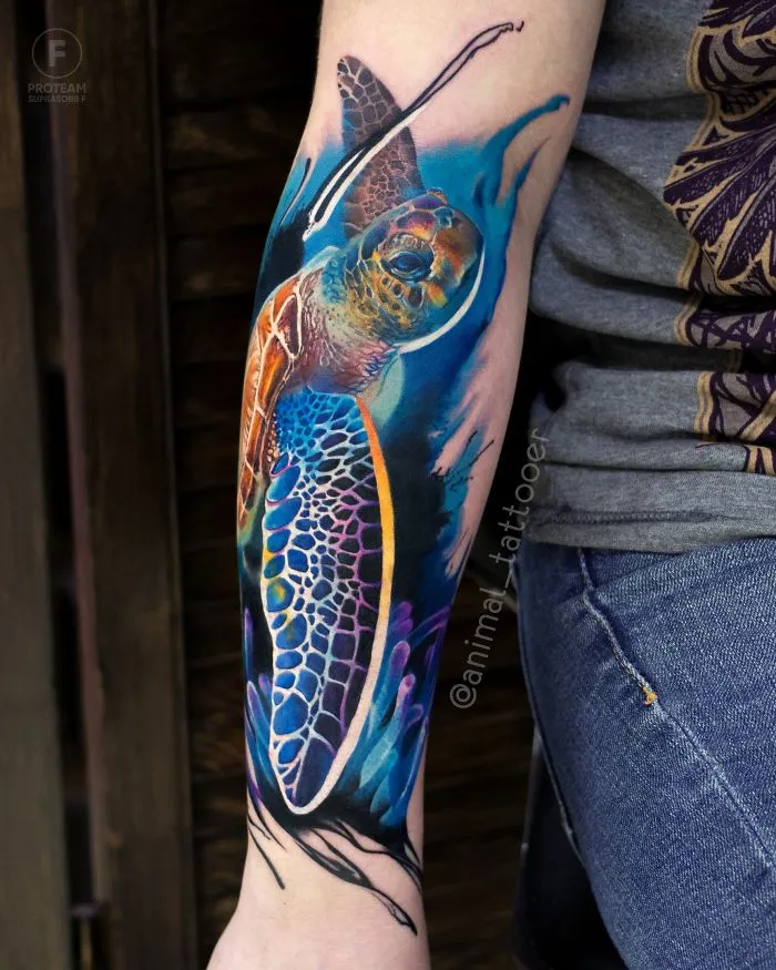 Colorful and bright animal tattoo of a sea turtle on a forearm, featuring vivid blues and oranges.
