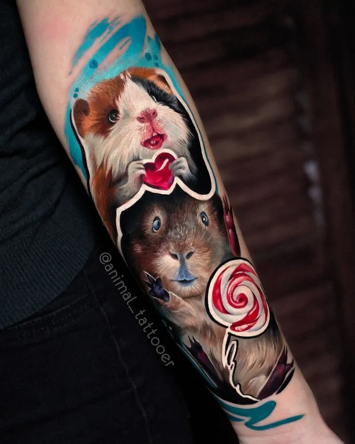 Colorful and bright animal tattoos of two guinea pigs holding a heart and a lollipop on a person's forearm.