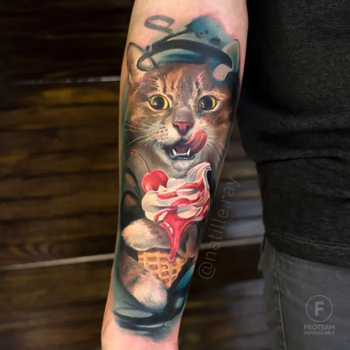 Colorful cat tattoo with a mischievous expression, holding ice cream, on a person's forearm.
