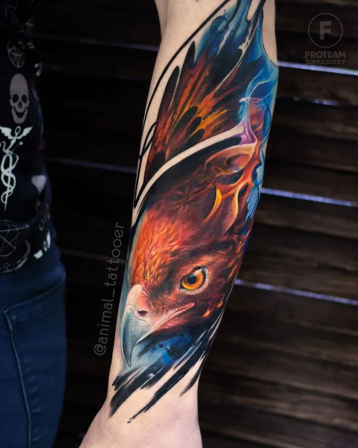 Colorful and bright animal tattoo of a bird on a person's forearm, showcasing vivid orange and blue hues.