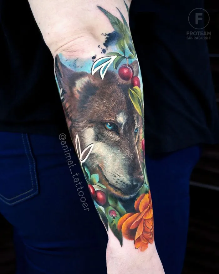 Colorful animal tattoo of a wolf on a person's forearm, featuring vibrant flowers and cherries.
