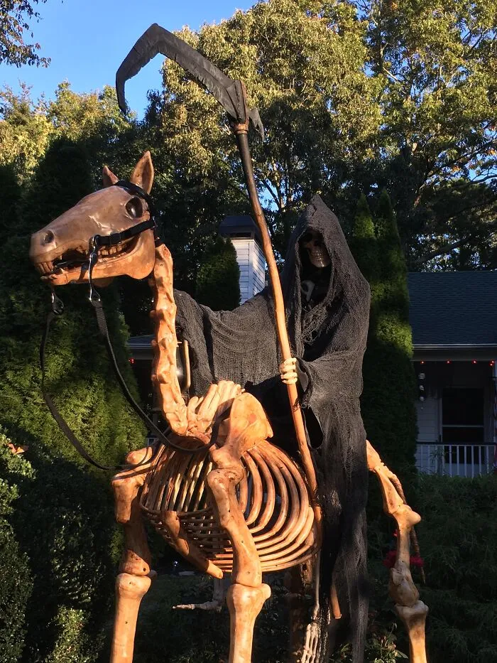 Grim Reaper Halloween decoration on a skeletal horse holding a scythe in an outdoor yard display for spooky season.