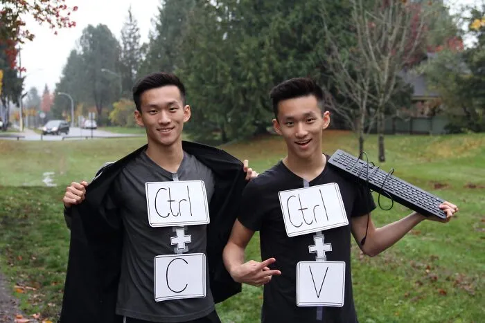 Identical twin brothers wearing Ctrl+C and Ctrl+V signs for clever Halloween costumes
