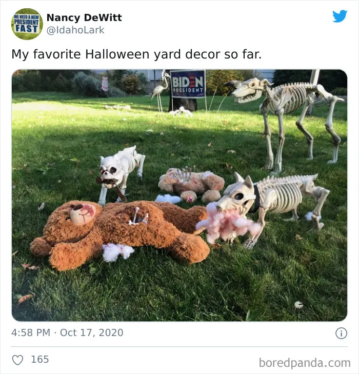 Halloween yard decorations featuring teddy bears torn apart by skeleton dogs on a sunny lawn, combining funny and frightening elements.