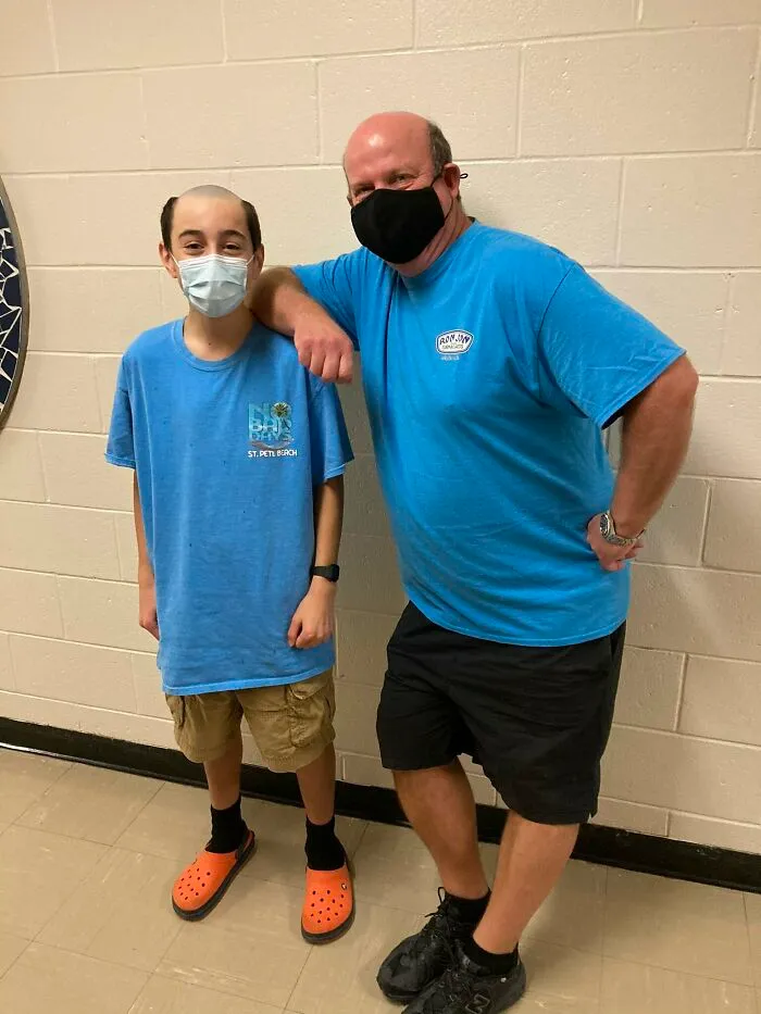 A boy and an adult man posing together with matching funny shaved haircuts as a Halloween costume.