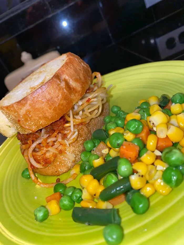 La cena de hoy es espaguetis entre pan de ajo con mezcla de verduras
