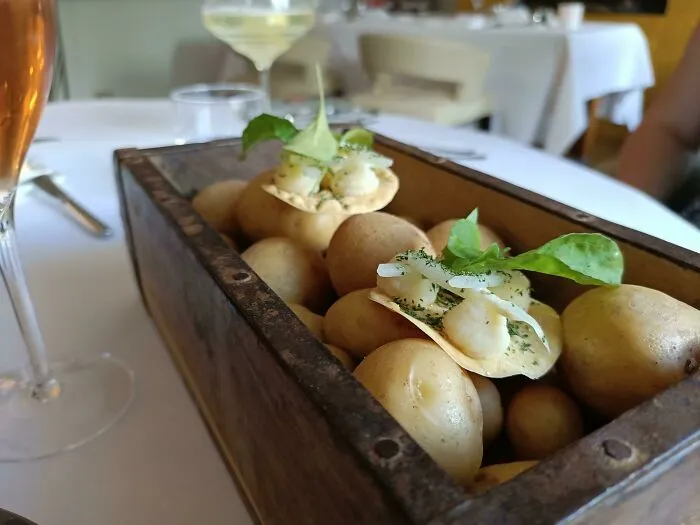 Little Bite Size Appetizer Served On A Box Of Uncooked Potatoes