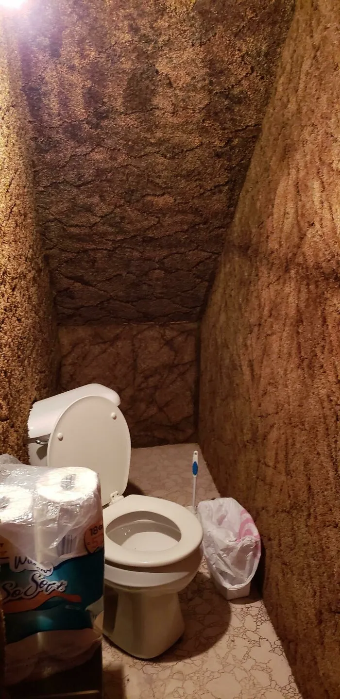 El "Baño" Debajo De Las Escaleras De Mi Amigo Donde El Inodoro Es Diagonal Y Está Parcialmente Instalado En Una Pared Alfombrada