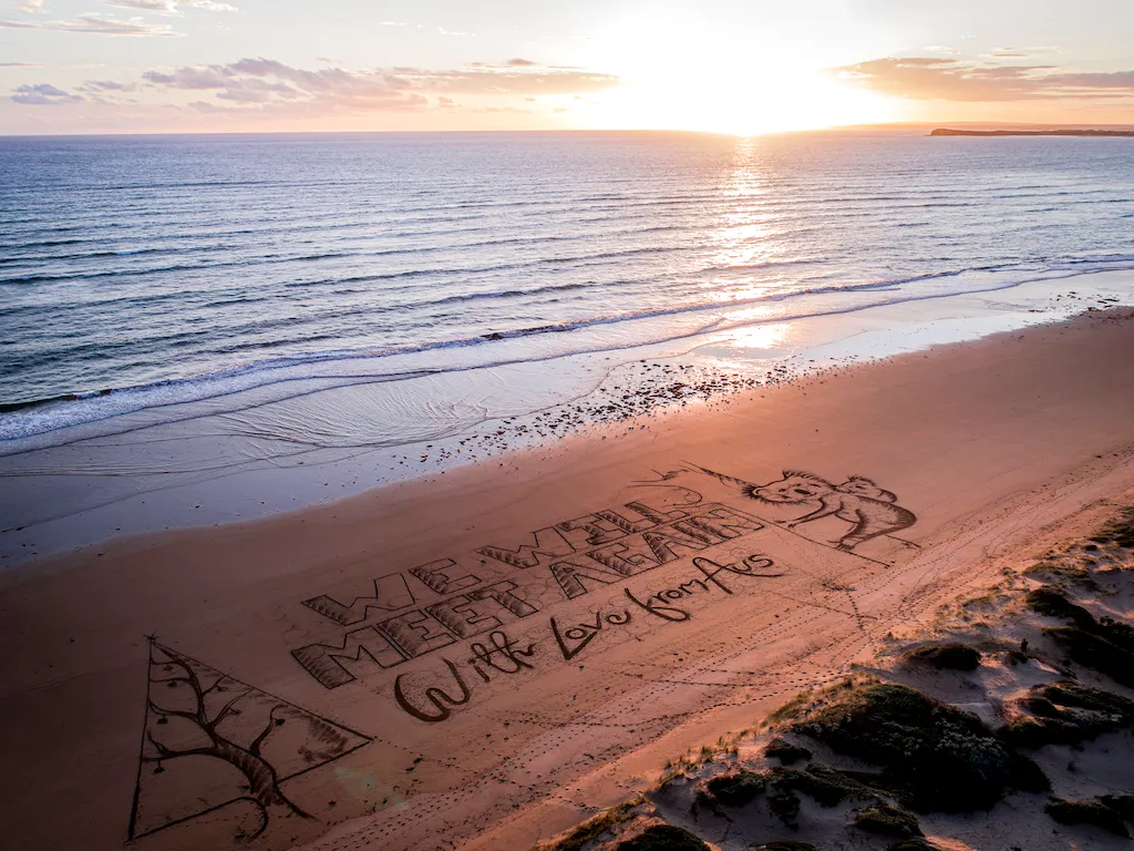 Artist Etches Giant Christmas Message From Aussies To Brits Into Beach