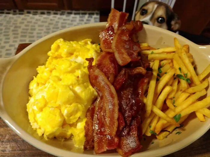 Huevos, bacon, patatas fritas y un buen chico observando