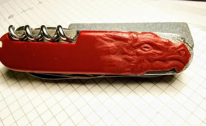 Un trozo del mango de mi navaja suiza se astilló, así que tallé una cabeza de dragón en el plástico para ocultarlo