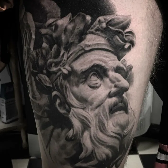 Black and gray realism tattoo by Swedish artist, depicting a classical bearded figure with laurel wreath.