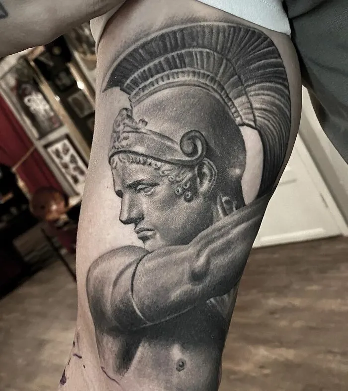 Black and gray realism tattoo of a Greek warrior on an arm by a Swedish artist.