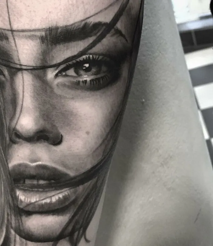 Black and gray realism tattoo of a woman's face by a Swedish artist, showcasing detailed and impressive artistry.