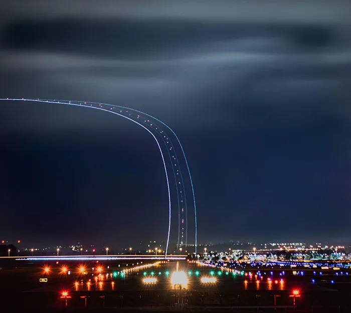 Autopista hacia el cielo. Exposición larga de 30 segundos de un avión que sale de la pista de aterrizaje