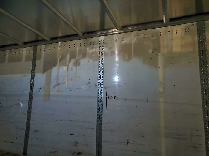 Hoy había un pequeño agujero en el lateral de un remolque que estaba cargando, lo que provocó que una imagen de la calle de fuera se proyectara al revés en la pared de enfrente