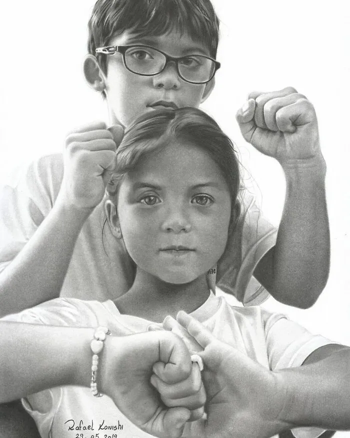 Realistic drawing by Rafael Konishi featuring two children with raised fists, showcasing detailed artistry.