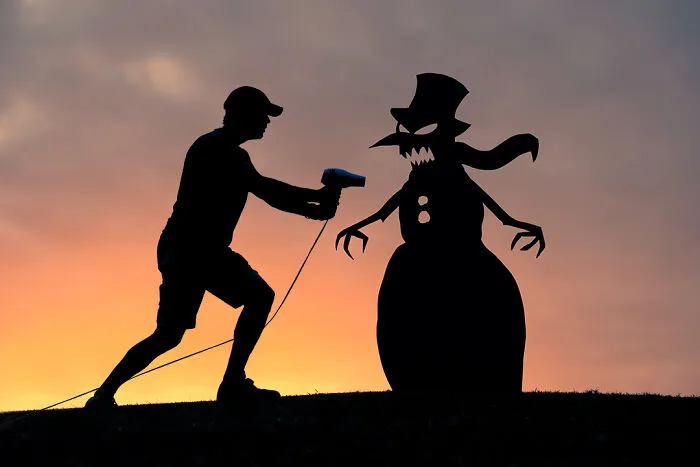 Silhouette of a person and a snowman cutout at sunset, capturing a playful mood for Valentine's Day.