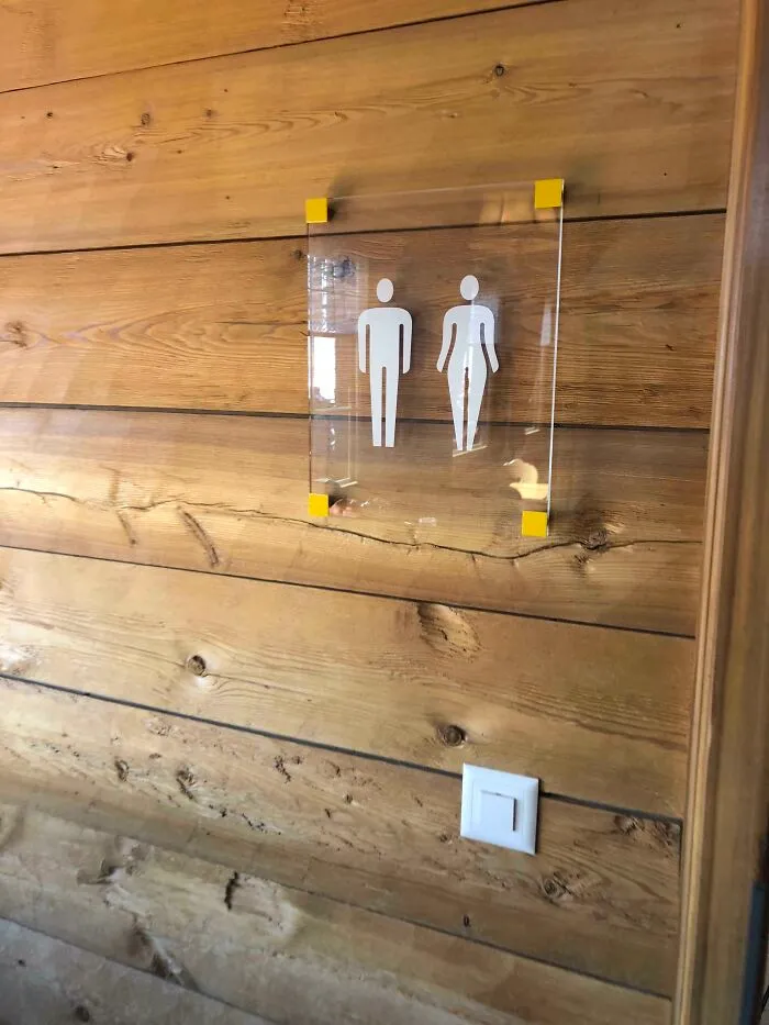 La mujer que aparece en este cartel del baño no lleva vestido