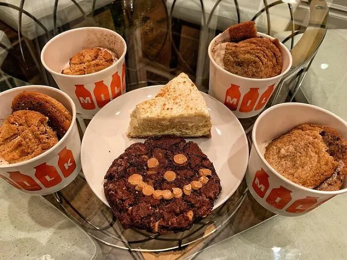 An Assortment Of Cookies And A Slice Chessecake To 