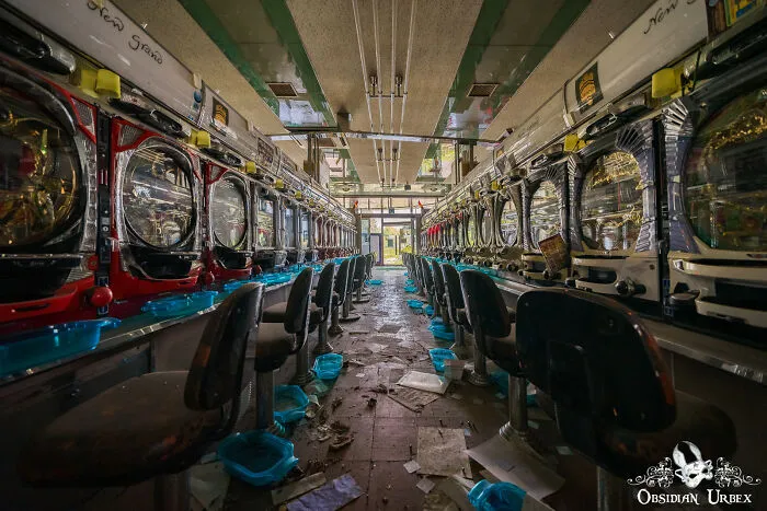 This Arcade Is Now Dark And Empty, With Coin Trays And Paper Littering The Floor