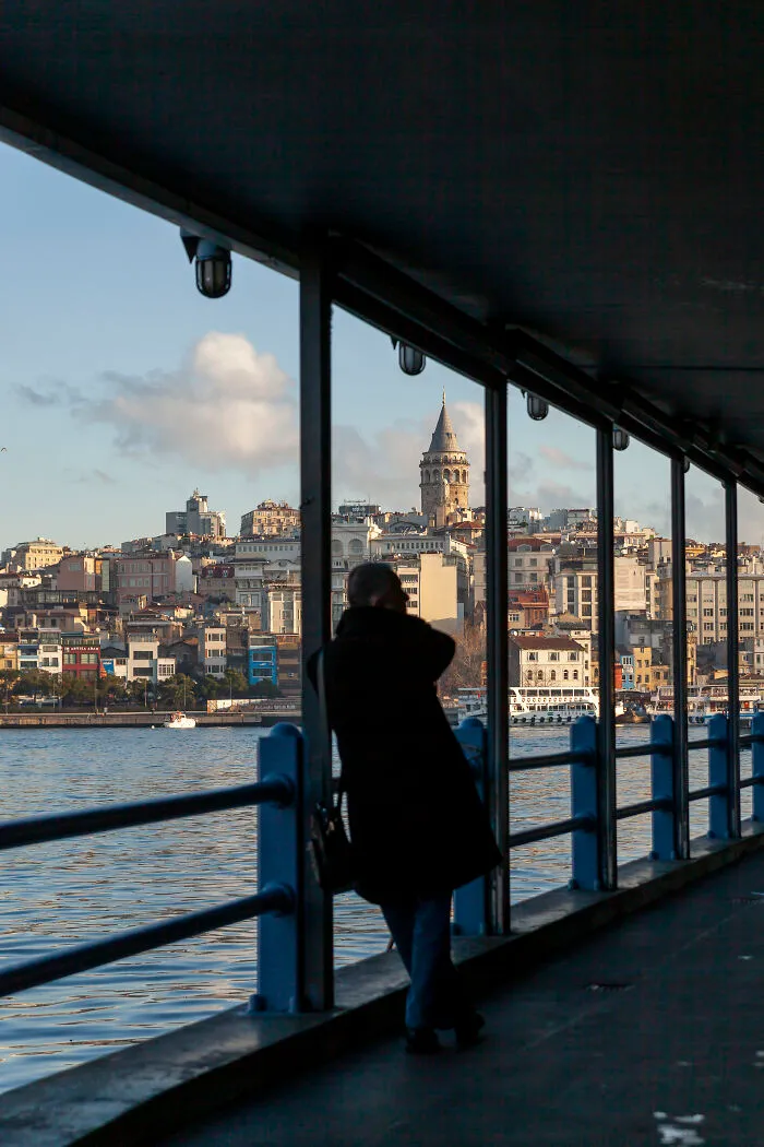Galata Tower Is One Of My Favorite Places In Istanbul. I Have Many Shots Of It From Different Angles, At Different Light Conditions. In This Case, I Took It From The Bridge Walkway And I Like The Framing Of The Man And The Tower