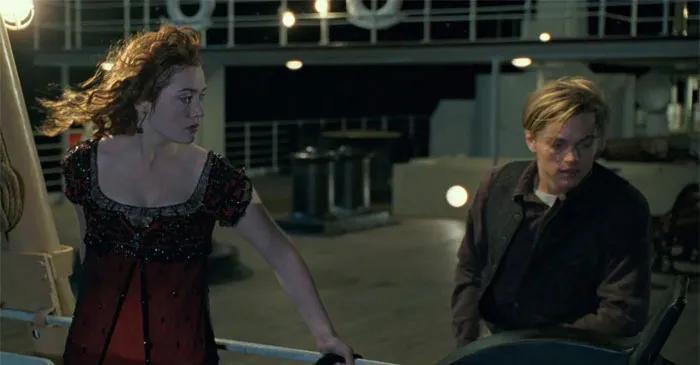 Rose standing behind the handrale of the ship and looking at Jack