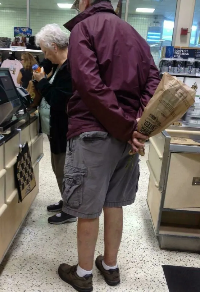 Estábamos en una larga fila en el supermercado. Este hombre dijo que tenía que usar el baño, pero en lugar de eso, compró flores para su esposa y las escondió detrás de su espalda